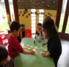 I bambini incollano le foglie sui rami