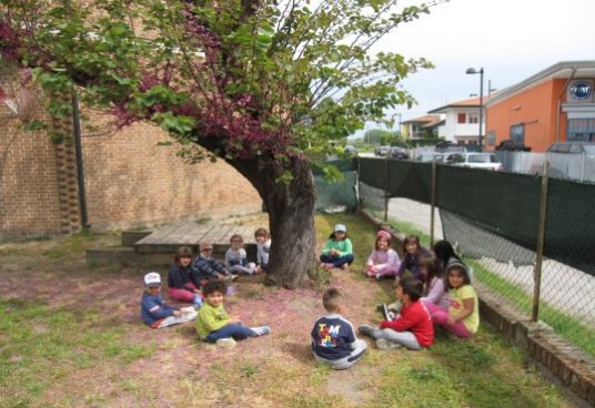 in giardino I bambini in cerchio attorno all'albero